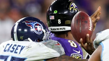 BALTIMORE, MARYLAND - JANUARY 11: Quarterback Lamar Jackson #8 of the Baltimore Ravens fumbles the ball while being hit by Jurrell Casey #99 of the Tennessee Titans in the second half of the AFC Divisional Playoff game at M&T Bank Stadium on January 11, 2020 in Baltimore, Maryland. (Photo by Rob Carr/Getty Images)