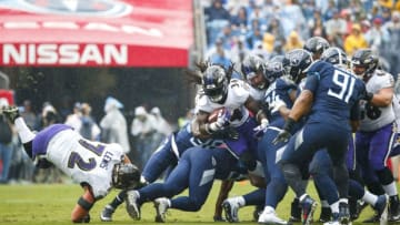 NASHVILLE, TN - OCTOBER 14: Alex Collins #34 of the Baltimore Ravens is tackled by multiple Tennessee Titans players while running with the ball during the first quarter at Nissan Stadium on October 14, 2018 in Nashville, Tennessee. (Photo by Frederick Breedon/Getty Images)