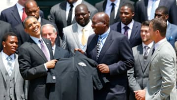 WASHINGTON, DC - JUNE 05: U.S. President Barack Obama (L) holds up a jacket given to him by general manager Ozzie Newsome (C) and head coach John Harbaugh (R) after welcoming members of the National Football League Super Bowl champion Baltimore Ravens during a South Lawn ceremony on June 5, 2013 in Washington, DC. The Ravens defeated the San Francisco 49ers 34-31 in Super Bowl XLVII. (Photo by Rob Carr/Getty Images)