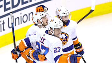 TORONTO, ONTARIO - AUGUST 26: Anders Lee #27 of the New York Islanders is congratulated by his teammates, Mathew Barzal #13 and Jordan Eberle #7 after scoring a goal against the Philadelphia Flyers during the second period in Game Two of the Eastern Conference Second Round during the 2020 NHL Stanley Cup Playoffs at Scotiabank Arena on August 26, 2020 in Toronto, Ontario. (Photo by Elsa/Getty Images)