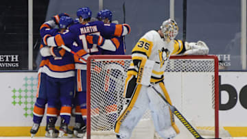 UNIONDALE, NEW YORK - FEBRUARY 06: The New York Islanders celebrate a goal by Cal Clutterbuck #15 against Tristan Jarry #35 of the Pittsburgh Penguins at 8:23 of the third period at the Nassau Coliseum on February 06, 2021 in Uniondale, New York. The Islanders defeated the Penguins 4-3. (Photo by Bruce Bennett/Getty Images)