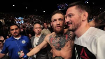Jul 11, 2015; Las Vegas, NV, USA; Chad Mendes (red gloves) is wobbled and ultimately knocked out by Conor McGregor (blue gloves) during their interim featherweight title bout during UFC 189 at MGM Grand Garden Arena. McGregor won via second round TKO. Mandatory Credit: Joe Camporeale-USA TODAY Sports