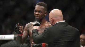 Jul 2, 2022; Las Vegas, Nevada, USA; Israel Adesanya (red gloves) reacts after defeating Jared Cannonier (blue gloves) during UFC 276 at T-Mobile Arena. Mandatory Credit: Stephen R. Sylvanie-USA TODAY Sports