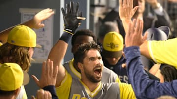 LOS ANGELES, CA - AUGUST 25: Austin Hedges #18 of the San Diego Padres is congratulated for his game tying run against the Los Angeles Dodgers in the nineth inning at Dodger Stadium on August 25, 2018 in Los Angeles, California. All players across MLB will wear nicknames on their backs as well as colorful, non-traditional uniforms featuring alternate designs inspired by youth-league uniforms during Players Weekend. (Photo by John McCoy/Getty Images)