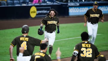 SAN DIEGO, CA - SEPTEMBER 28: Freddy Galvis #13 of the San Diego Padres, center, is congratulated after hitting a walk-off double during the 15th inning of a baseball game against the Arizona Diamondbacks at PETCO Park on September 28, 2018 in San Diego, California. The Padres won 3-2. (Photo by Denis Poroy/Getty Images)