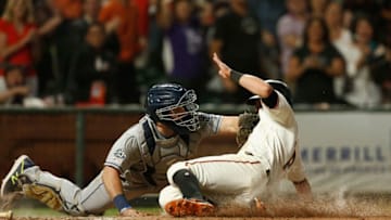 SAN FRANCISCO, CALIFORNIA - JUNE 11: Joe Panik #12 of the San Francisco Giants slides in safe at home plate against Austin Hedges #18 of the San Diego Padres to score on a double hit by teammate Evan Longoria #10 in the bottom of the seventh inning against the San Diego Padres at Oracle Park on June 11, 2019 in San Francisco, California. (Photo by Lachlan Cunningham/Getty Images)