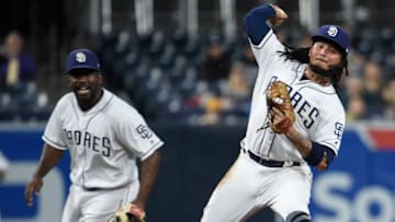 SAN DIEGO, CA - MAY 29: Freddy Galvis #13 of the San Diego Padres throws to first base as Jose Pirela #2 looks on during the second inning of a baseball game against the Miami Marlins at PETCO Park on May 29, 2018 in San Diego, California. Galvis was unable to get the out on Lewis Brinson #9 of the Miami Marlins. (Photo by Denis Poroy/Getty Images)