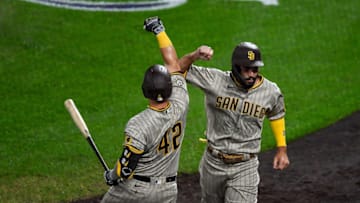 DENVER, CO - AUGUST 28: Eric Hosmer #42 of the San Diego Padres is congratulated by Ty France #42 after scoring a run in the fourth inning of a game against the Colorado Rockies at Coors Field on August 28, 2020 in Denver, Colorado. All players are wearing #42 in honor of Jackie Robinson Day. The day honoring Jackie Robinson, traditionally held on April 15, was rescheduled due to the COVID-19 pandemic. (Photo by Dustin Bradford/Getty Images)