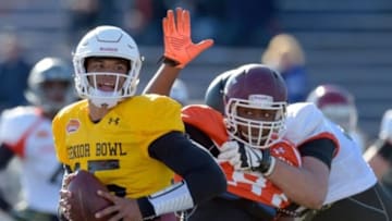 Jan 28, 2016; Mobile, AL, USA; South squad quarterback Dak Prescott of Mississippi State (15) avoids the pressure of defensive end Noah Spence of Eastern Kentucky (97) during Senior Bowl practice at Ladd-Peebles Stadium. Mandatory Credit: Glenn Andrews-USA TODAY Sports