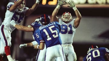 Jan 27, 1991; Tampa, FL, USA; FILE PHOTO; New York Giants quarterback Jeff Hostetler (15) throws the ball while center Bart Oates (65) and guard Eric Moore (60) block Buffalo Bills linebacker Shane Conlan (58) and nose tackle Jeff Wright (91) during Super Bowl XXV at Tampa Stadium. The Giants defeated the Bills 19-20. Mandatory Credit: USA TODAY Sports