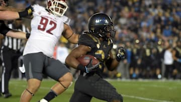 Nov 14, 2015; Pasadena, CA, USA; UCLA Bruins running back Paul Perkins (24) is pursued by Washington State Cougars nose tackle Robert Barber (92) in a NCAA football game at Rose Bowl. Mandatory Credit: Kirby Lee-USA TODAY Sports