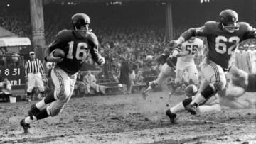 New York Giants football player Frank Gifford (#16) runs with protection from teammate Darrell Dess (#62) during a game against the Philadelphia Eagles, 1960s. (Photo by Robert Riger/Getty Images)