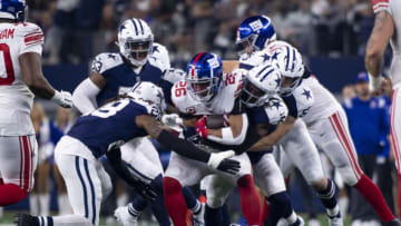 Nov 24, 2022; Arlington, Texas, USA; New York Giants running back Saquon Barkley (26) is tackled by the Dallas Cowboys defense during the second half of the game between the Cowboys and the Giants at AT&T Stadium. Mandatory Credit: Jerome Miron-USA TODAY Sports