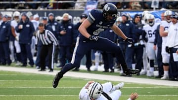 Nov 28, 2015; Logan, UT, USA; Brigham Young Cougars quarter back Tanner Mangum (12) slides under Utah State Aggies linebacker Kyler Fackrell (9) during the second quarter at Romney Stadium. Mandatory Credit: Chris Nicoll-USA TODAY Sports