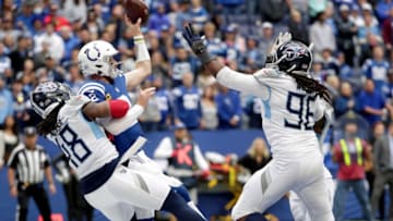 Indianapolis Colts quarterback Carson Wentz (2) throws the ball as he's brought down in the end zone by Tennessee Titans outside linebacker Bud Dupree (48) on Sunday, Oct. 31, 2021, during a game against the Tennessee Titans at Lucas Oil Stadium in Indianapolis. The pass was intercepted and ran in for a touchdown by Tennessee Titans cornerback Elijah Molden (24).