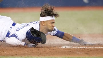 TORONTO, ON - APRIL 25: Lourdes Gurriel Jr. #13 of the Toronto Blue Jays slides across home plate to score a run in the fifth inning during MLB game action against the Boston Red Sox at Rogers Centre on April 25, 2018 in Toronto, Canada. (Photo by Tom Szczerbowski/Getty Images)