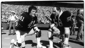 SAN FRANCISCO - AUGUST 20: Linebackers Phil Villapiano #41 and Monte Johnson #58 of the Oakland Raiders kneel on the sideline during a preseason game against the San Francisco 49ers at Candlestick Park on Aguust 20, 1978 in San Francisco, California. (Photo by Michael Zagaris/Getty Images)