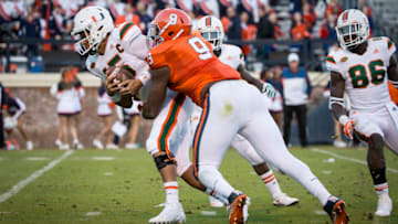 CHARLOTTESVILLE, VA - NOVEMBER 12: Brad Kaaya No. 15 of the Miami Hurricanes is sacked by Andrew Brown No. 9 of the Virginia Cavaliers during a game at Scott Stadium on November 12, 2016 in Charlottesville, Virginia. (Photo by Chet Strange/Getty Images)