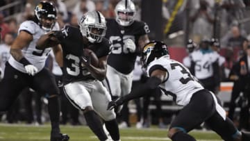 Aug 4, 2022; Canton, Ohio, USA; Las Vegas Raiders running back Zamir White (35) runs the ball against Jacksonville Jaguars safety Andre Cisco (38) in the first quarter the Hall of Fame game at Tom Benson Hall of Fame Stadium. Mandatory Credit: Kirby Lee-USA TODAY Sports