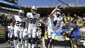Sep 19, 2021; Pittsburgh, Pennsylvania, USA; Las Vegas Raiders running back Kenyan Drake (23) and defensive end Maxx Crosby (98) and quarterback Derek Carr (4) lead the Raiders onto the field to play the Pittsburgh Steelers at Heinz Field. Mandatory Credit: Charles LeClaire-USA TODAY Sports
