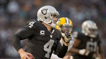 OAKLAND, CA - DECEMBER 20: Quarterback Derek Carr #4 of the Oakland Raiders looks for a receiver downfield against linebacker Mike Neal #96 of the Green Bay Packers late in the game on December 20, 2015 at O.co Coliseum in Oakland, California. The Packers won 30-20. (Photo by Brian Bahr/Getty Images)