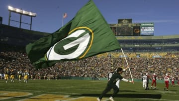 GREEN BAY, WI - OCTOBER 29: A cheedleader carries a Packer flag across the end zone after the Green Bay Packers scored a touchdown against the Arizona Cardinals on October 29, 2006 at Lambeau Field in Green Bay, Wisconsin. The Packers won 31-14. (Photo by Stephen Dunn/Getty Images)