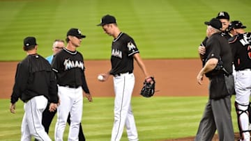 Jul 30, 2016; Miami, FL, USA; Miami Marlins staring pitcher Colin Rea (right) hands the baseball to Marlins manager Don Mattingly (left) after Rea injured his arm during the fourth inning against the St. Louis Cardinals at Marlins Park. Mandatory Credit: Steve Mitchell-USA TODAY Sports