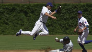 CHICAGO - JULY 12: Second Baseman Mark Belhorn #28 of the Chicago Cubs leaps over sliding second baseman Luis Castillo #1 of the Florida Marlins as he gloves the ball during the game on July 12, 2002 at Wrigley Field in Chicago, Illinois. The Cubs defeated the Marlins 5-4 in 16 innings. (Photo by Jonathan Daniel/Getty Images)