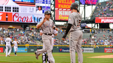 DENVER, CO - JUNE 24: J.T. Realmuto #11 of the Miami Marlins crosses the plate and starts to celebrate with Brian Anderson #15 after the two scored in the first inning of the of a game against the Colorado Rockies at Coors Field on June 24, 2018 in Denver, Colorado. (Photo by Dustin Bradford/Getty Images)