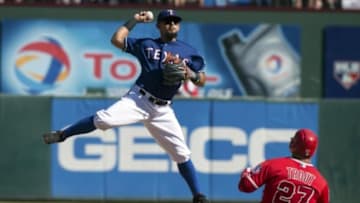 Oct 4, 2015; Arlington, TX, USA; Texas Rangers second baseman Rougned Odor (12) turns a double play as Los Angeles Angels center fielder Mike Trout (27) slides into second base during the game at Globe Life Park in Arlington. The Texas Rangers defeat the Angels 9-2 and clinch the American League West division. Mandatory Credit: Jerome Miron-USA TODAY Sports