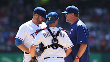 Apr 6, 2016; Arlington, TX, USA; Texas Rangers starting pitcher Colby Lewis (48) talks with catcher Bryan Holaday (8) and pitching coach Doug Brocail in the first inninig against the Seattle Mariners at Globe Life Park in Arlington. Mandatory Credit: Matthew Emmons-USA TODAY Sports