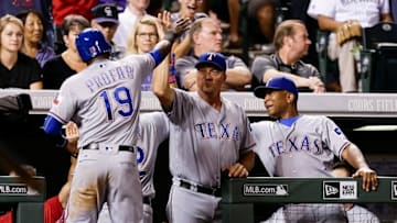 Aug 8, 2016; Denver, CO, USA; Texas Rangers third baseman Jurickson Profar (19) celebrates with manager Jeff Banister (28) and third base coach Tony Beasley (27) after scoring the tying run in the ninth inning against the Colorado Rockies at Coors Field. The Rangers defeated the Rockies 4-3. Mandatory Credit: Isaiah J. Downing-USA TODAY Sports