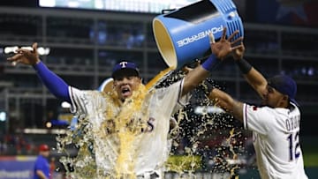 Sep 28, 2016; Arlington, TX, USA; Texas Rangers left fielder Carlos Gomez (14) is doused by second baseman Rougned Odor (12) and shortstop Hanser Alberto (2) following the 8-5 win over the Milwaukee Brewers during a baseball game at Globe Life Park in Arlington. Mandatory Credit: Jim Cowsert-USA TODAY Sports