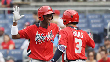 WASHINGTON, DC - JULY 15: Seuly Matias #25 of the Kansas City Royals and the World Team celebrates with teammate Leody Taveras #3 of the Texas Rangers and the World Team after after hitting a solo home run against the U.S. Team in the second inning during the SiriusXM All-Star Futures Game at Nationals Park on July 15, 2018 in Washington, DC. (Photo by Rob Carr/Getty Images)