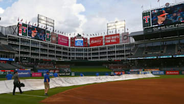 ARLINGTON, TX - APRIL 06: The Texas Rangers ground crew removes the tarp off the infield during a forty five minute rain delay before the game against the Toronto Blue Jays at Globe Life Park in Arlington on April 6, 2018 in Arlington, Texas. (Photo by Rick Yeatts/Getty Images)