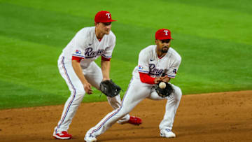 Apr 12, 2022; Arlington, Texas, USA; Texas Rangers second baseman Marcus Semien (2) fields a ground ball in front of Texas Rangers shortstop Corey Seager (5) during the fifth inning against the Colorado Rockies at Globe Life Field. Mandatory Credit: Kevin Jairaj-USA TODAY Sports