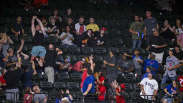 Sep 21, 2022; Arlington, Texas, USA; A fan attempts to catch a home run ball hit by Los Angeles Angels right fielder Taylor Ward (not pictured) during the first inning against the Texas Rangers at Globe Life Field. Mandatory Credit: Jerome Miron-USA TODAY Sports