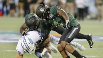 Dec 29, 2015; Orlando, FL, USA; North Carolina Tar Heels wide receiver Mack Hollins (13) is tackled by Baylor Bears cornerback Xavien Howard (4) and Ryan Reid (9) during the first quarter of the Russell Athletic Bowl at Florida Citrus Bowl. Mandatory Credit: Reinhold Matay-USA TODAY Sports