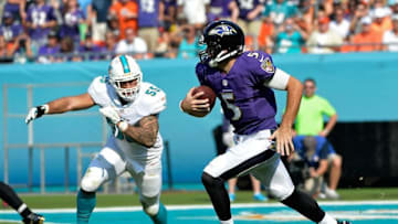 Dec 7, 2014; Miami Gardens, FL, USA; Baltimore Ravens quarterback Joe Flacco (5) runs past Miami Dolphins outside linebacker Koa Misi (55) during the first half at Sun Life Stadium. Mandatory Credit: Steve Mitchell-USA TODAY Sports