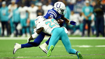 INDIANAPOLIS, INDIANA - NOVEMBER 25: Nyheim Hines #42 of the Indianapolis Colts is tackled by Reshad Jones #20 of the Miami Dolphins in the fourth quarter at Lucas Oil Stadium on November 25, 2018 in Indianapolis, Indiana. (Photo by Stacy Revere/Getty Images)