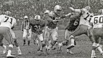 CLEVELAND, OH - NOVEMBER 28: (EDITORS NOTE: Image has been shot in black and white. Color version not available.) Running back Norm Bulaich #31 of the Miami Dolphins runs behind the blocking of center Jim Langer #62 and guard Bob Kuechenberg #67 as defensive linemen Walter Johnson #71 and Jerry Sherk #72 and linebacker Bob Babich #60 of the Cleveland Browns pursue the play as snow falls during a game at Cleveland Municipal Stadium on November 28, 1976 in Cleveland, Ohio. The Browns defeated the Dolphins 17-13. (Photo by George Gojkovich/Getty Images)