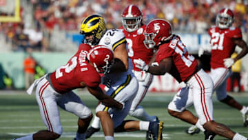 ORLANDO, FL - JANUARY 01: Patrick Surtain II #2 and Xavier McKinney #15 of the Alabama Crimson Tide tackle Zach Charbonnet #24 of the Michigan Wolverines in the third quarter of the Vrbo Citrus Bowl at Camping World Stadium on January 1, 2020 in Orlando, Florida. Alabama defeated Michigan 35-16. (Photo by Joe Robbins/Getty Images)