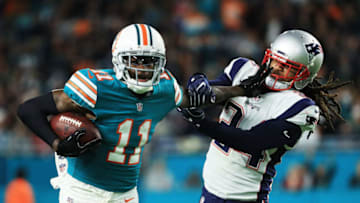 MIAMI GARDENS, FL - DECEMBER 11: DeVante Parker #11 of the Miami Dolphins tries to avoid the tackle of Stephon Gilmore #24 of the New England Patriots in the third quarter at Hard Rock Stadium on December 11, 2017 in Miami Gardens, Florida. (Photo by Mike Ehrmann/Getty Images)