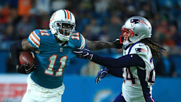 MIAMI GARDENS, FL - DECEMBER 11: DeVante Parker #11 of the Miami Dolphins stiff arms Stephon Gilmore #24 of the New England Patriots during the first quarter at Hard Rock Stadium on December 11, 2017 in Miami Gardens, Florida. (Photo by Chris Trotman/Getty Images)