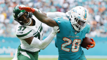 MIAMI GARDENS, FLORIDA - DECEMBER 19: Duke Johnson #28 of the Miami Dolphins runs with the ball against Bryce Hall #37 of the New York Jets in the fourth quarter at Hard Rock Stadium on December 19, 2021 in Miami Gardens, Florida. (Photo by Cliff Hawkins/Getty Images)