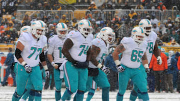 PITTSBURGH, PA - DECEMBER 8: Members of the offensive line of the Miami Dolphins, including tackles Tyson Clabo #77 and Bryant McKinnie #78, guards John Jerry #74 and Sam Brenner #65 and center Mike Pouncey #51, walk to the line of scrimmage as snow falls during a game against the Pittsburgh Steelers at Heinz Field on December 8, 2013 in Pittsburgh, Pennsylvania. The Dolphins defeated the Steelers 34-28. (Photo by George Gojkovich/Getty Images)