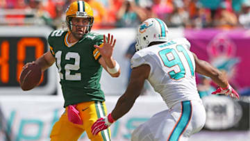 MIAMI GARDENS, FL - OCTOBER 12: Quarterback Aaron Rodgers #12 of the Green Bay Packers tries to hold off defender defensive end Cameron Wake #91 of the Miami Dolphins in the third quarter during a game at Sun Life Stadium on October 12, 2014 in Miami Gardens, Florida. (Photo by Mike Ehrmann/Getty Images)