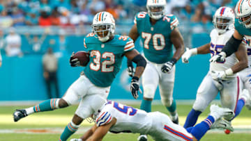MIAMI, FL - DECEMBER 02: Kenyan Drake #32 of the Miami Dolphins breaks a tackle from Matt Milano #58 of the Buffalo Bills during the first half at Hard Rock Stadium on December 2, 2018 in Miami, Florida. (Photo by Michael Reaves/Getty Images)
