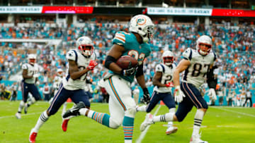 MIAMI, FL - DECEMBER 09: Kenyan Drake #32 of the Miami Dolphins carries the ball for the game winning touchdown during the fourth quarter against the New England Patriots at Hard Rock Stadium on December 9, 2018 in Miami, Florida. (Photo by Michael Reaves/Getty Images)