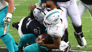 Dec 26, 2020; Paradise, Nevada, USA; Miami Dolphins quarterback Tua Tagovailoa (1) is sacked by Las Vegas Raiders defensive tackle Kendal Vickers (91) during the second half at Allegiant Stadium. Mandatory Credit: Mark J. Rebilas-USA TODAY Sports